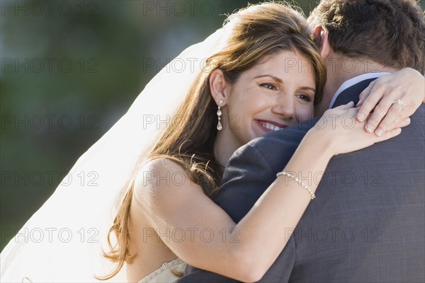 Multi-ethnic bride hugging father