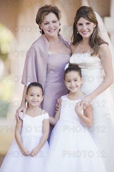 Multi-ethnic bride with mother and flower girls