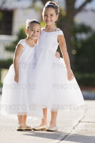 Multi-ethnic flower girls hugging