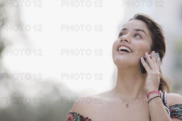 Brazilian teenager talking cell phone looking up