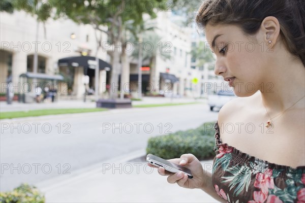 Brazilian teenager text messaging on cell phone