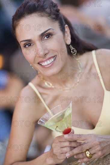 Mixed race woman holding martini glass