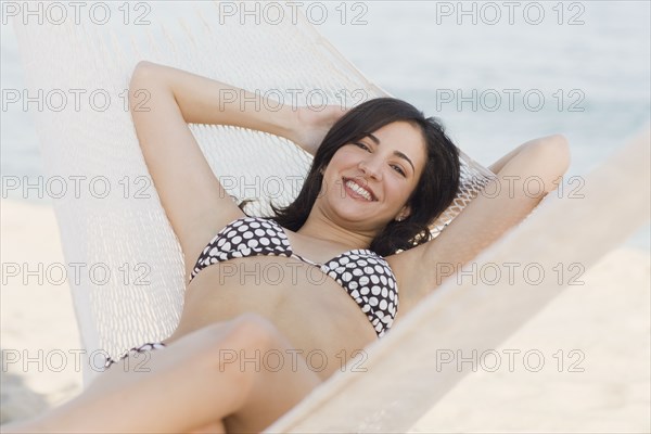 Cuban woman laying in hammock on beach