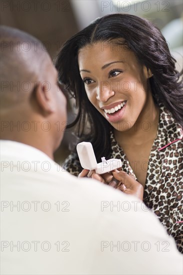 African man giving girlfriend engagement ring