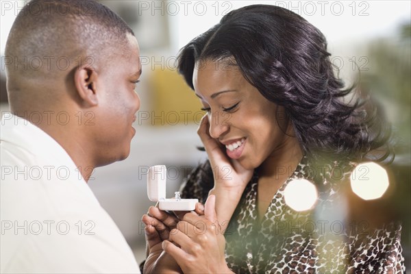 African man giving girlfriend engagement ring