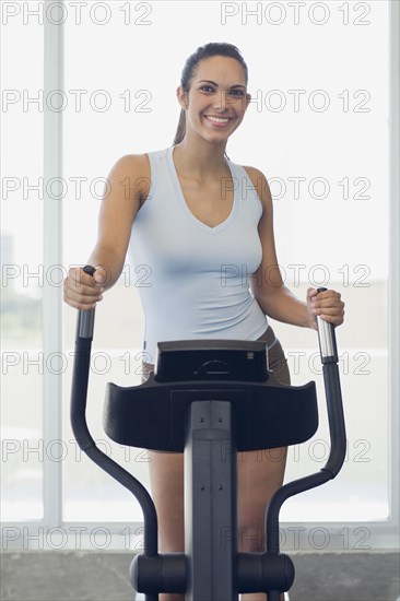 Hispanic woman exercising in health club