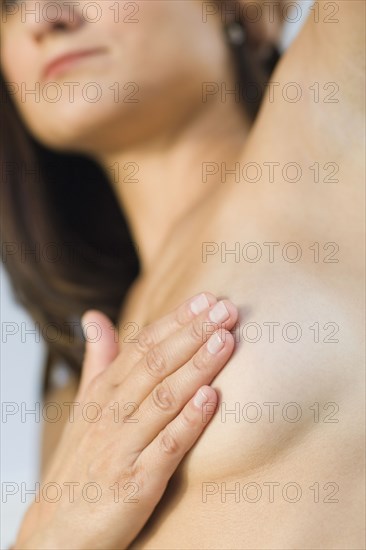 Close up of Hispanic woman doing breast self-exam