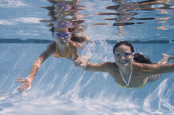 Mother and daughter swimming in swimming pool