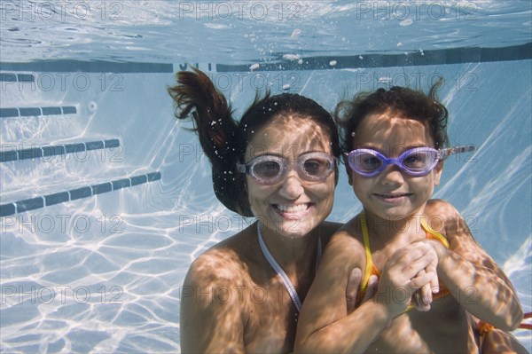 Mother and daughter swimming in swimming pool