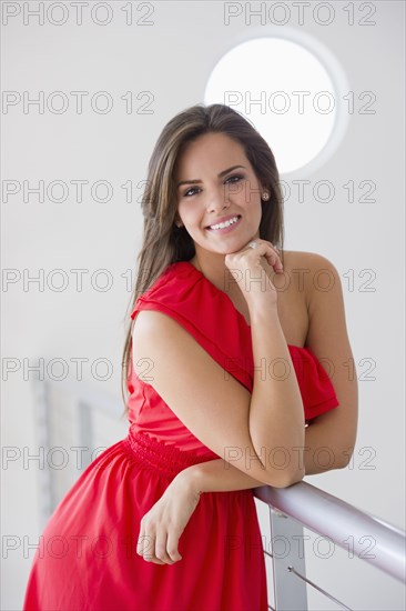 Glamorous Hispanic woman leaning on railing