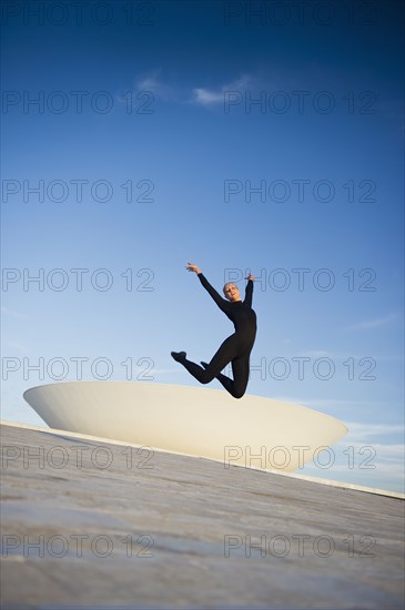 Brazilian dancer jumping in mid-air outdoors