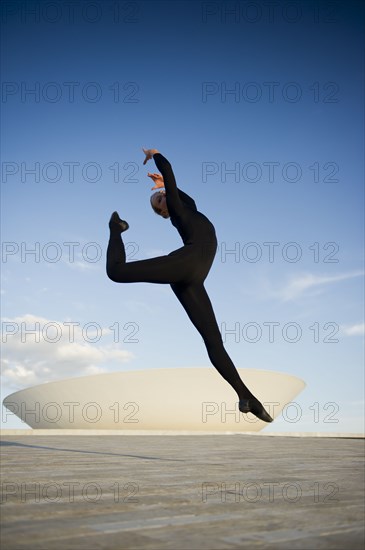 Brazilian dancer jumping in mid-air outdoors