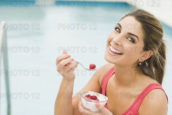 Caucasian woman eating yogurt and berries