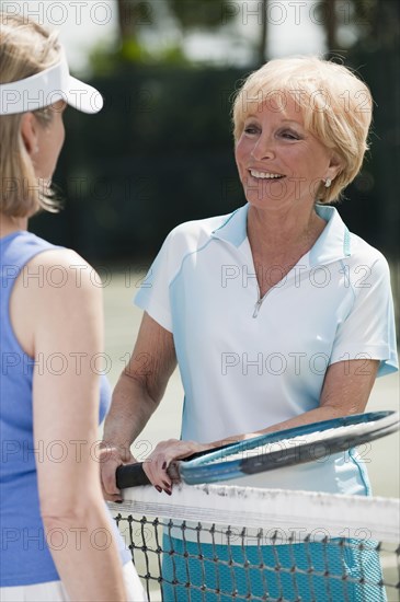 Caucasian women playing tennis