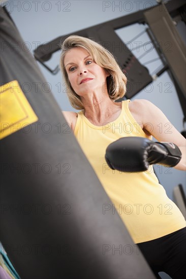 Caucasian woman boxing with punching bag