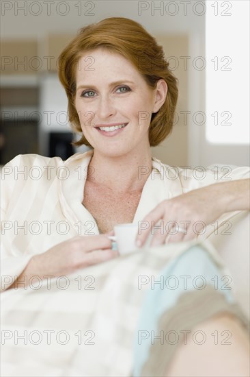 Smiling Caucasian woman drinking coffee