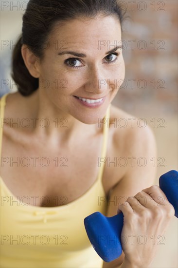Hispanic woman exercising with dumbbells