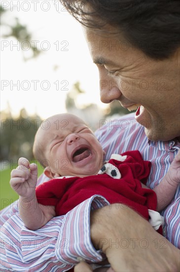 Caucasian father holding crying daughter