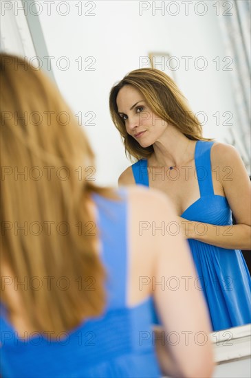 Hispanic woman looking in mirror