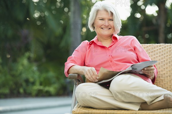 Caucasian woman reading magazine outdoors