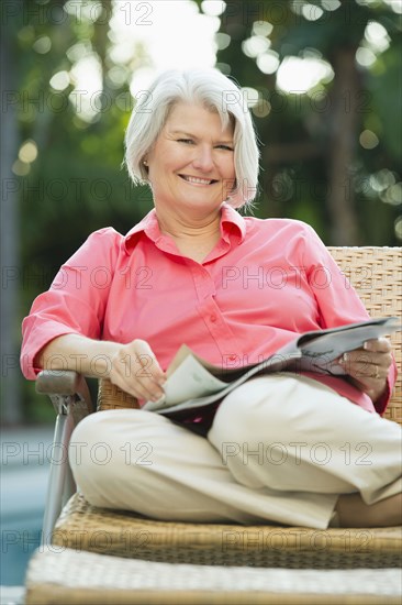 Caucasian woman reading magazine outdoors