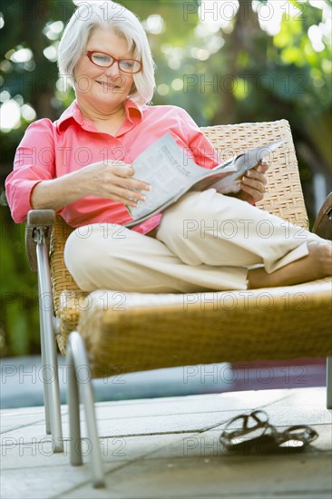 Caucasian woman reading magazine outdoors