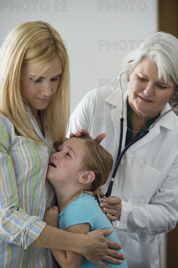 Crying girl having checkup in doctor's office