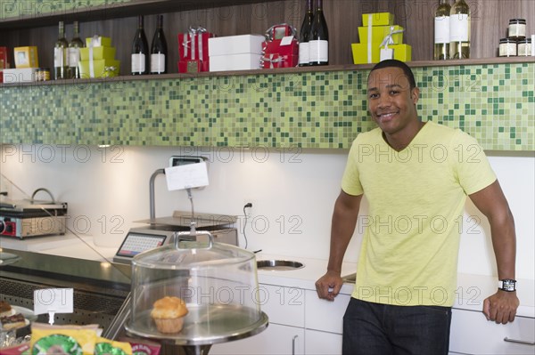 Mixed race business owner leaning on shop counter