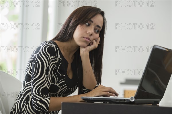 Mixed race businesswoman typing on laptop