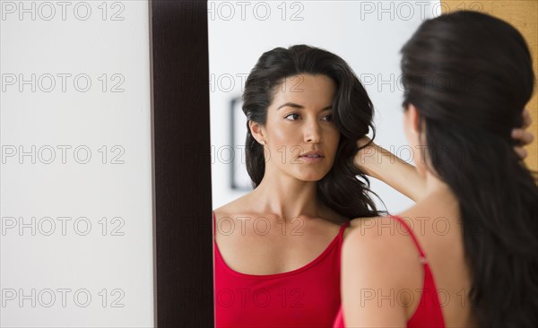 Hispanic woman looking at her reflection