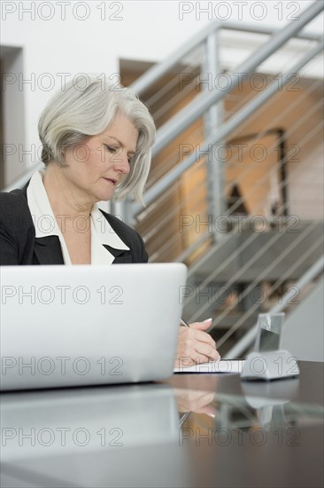 Businesswoman at desk writing