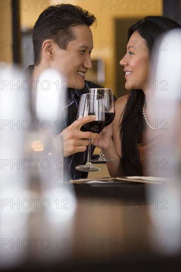 Couple toasting with red wine in restaurant