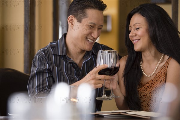 Couple toasting with red wine in restaurant