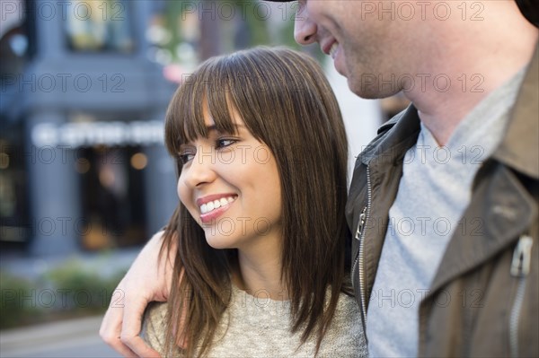 Smiling couple walking on city street