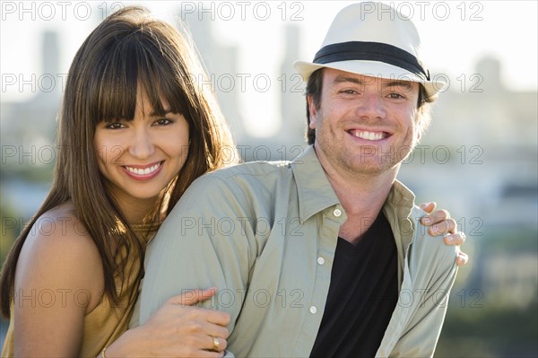 Smiling couple hugging on city street