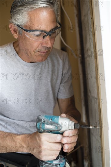 Caucasian man using power drill