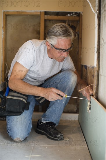 Caucasian man using screwdriver