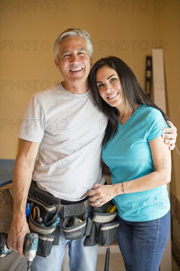 Smiling contractor hugging wife