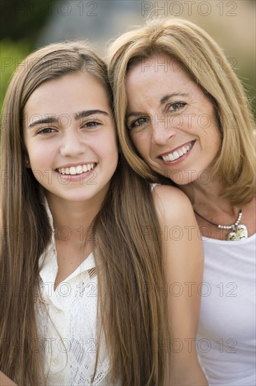 Caucasian mother and daughter smiling outdoors