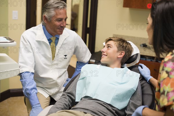 Dentist and nurse talking to patient