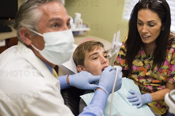 Dentist and nurse examining patient's mouth