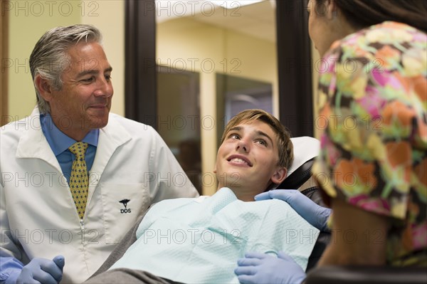 Dentist and nurse talking to patient