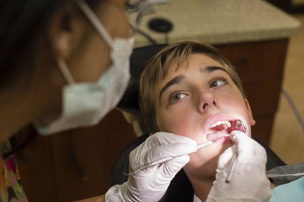Nurse examining dental patient's mouth