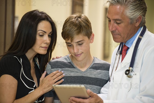 Mother and son using digital tablet with dentist