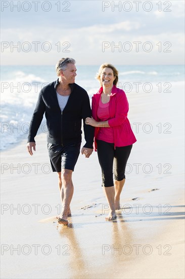 Caucasian couple walking on beach