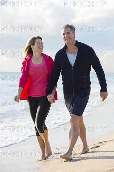 Caucasian couple walking on beach