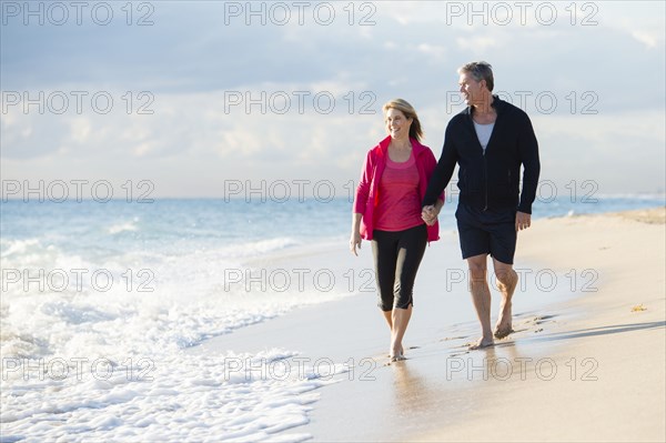 Caucasian couple walking on beach