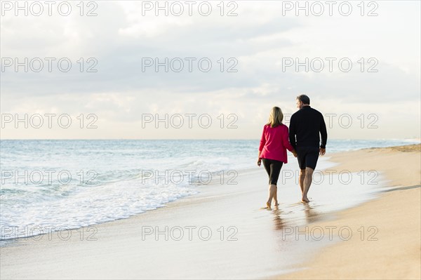 Caucasian couple walking on beach