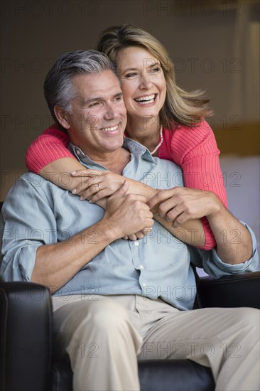 Caucasian couple hugging in armchair