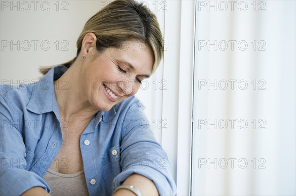 Caucasian woman smiling in window